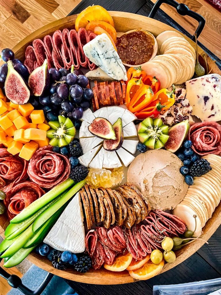a large charcuterie board with lots of meats, cheeses, and accoutrements to show how to make a charcuterie board