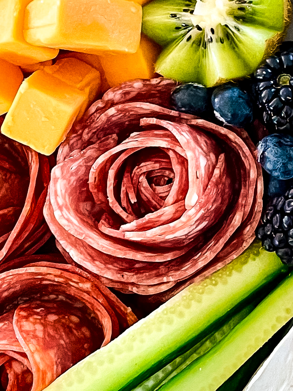 A closeup of a salami rose that's part of a larger salami charcuterie board
