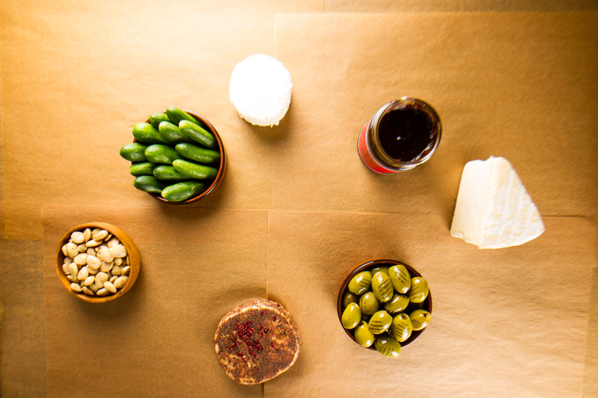 Step two of building a $100 Trader Joe's grazing table: adding cheese (Saint Andre, Boursin, Stilton with Cranberries, and Pink Peppercorn Fontina)