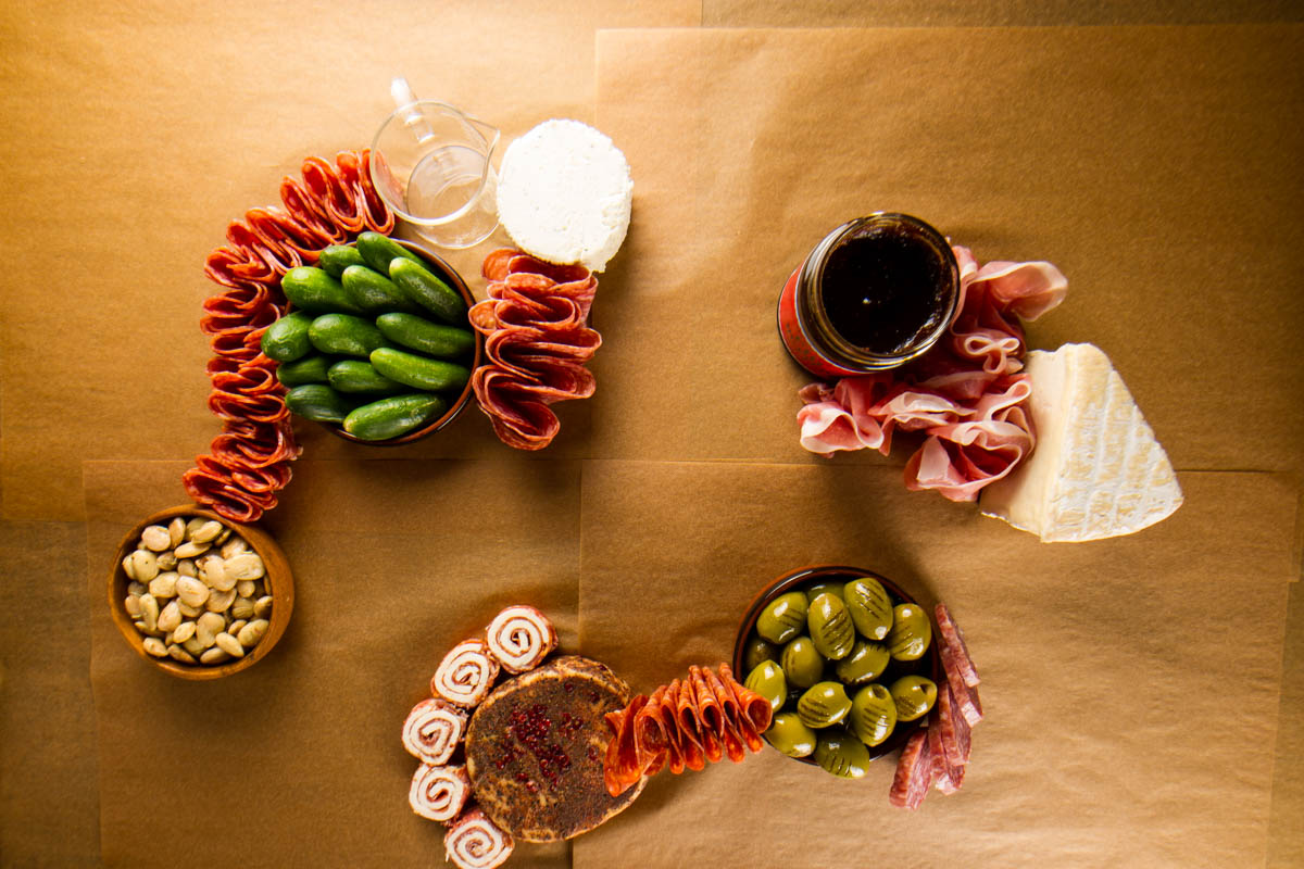 Step three of building a $100 Trader Joe's grazing table: adding calabrese, salami, and prosciutto to the board