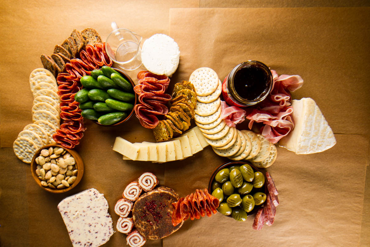 Step four of building a $100 Trader Joe's grazing table: adding water crackers and pumpkin cranberry crisps