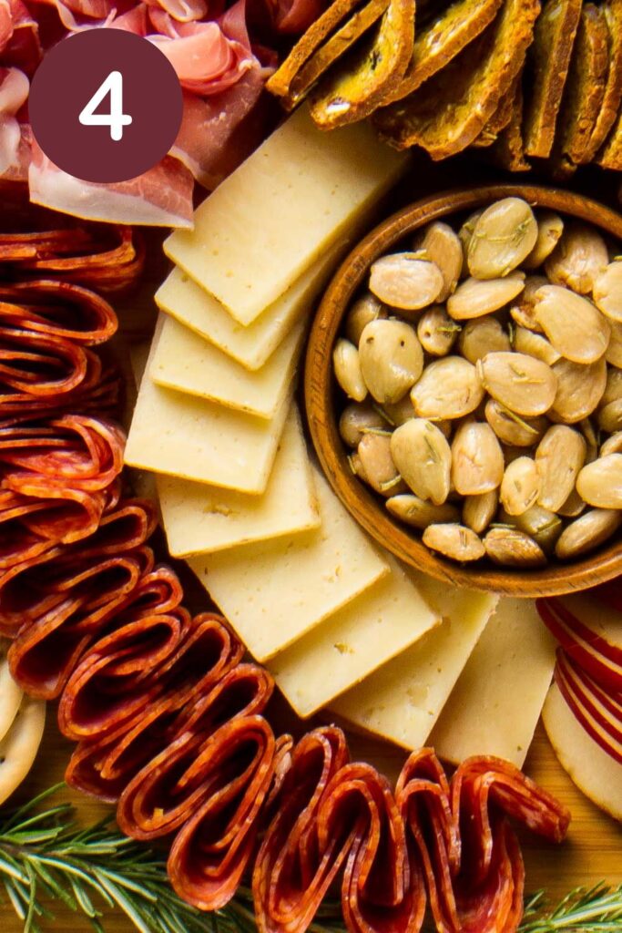 Step four of how to cut Trader Joe's Toscano cheese: a river of rectangular slices winding around a bowl of almonds with a round circle and a white #4