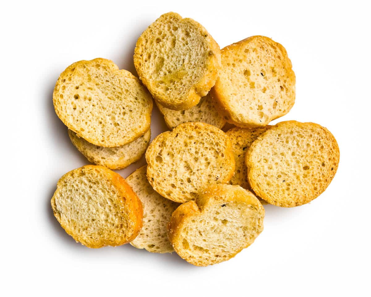 a small pile of freshly toasted crostini on a white background